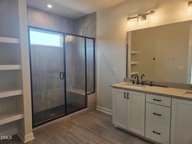 a bathroom with a shower sink and mirror