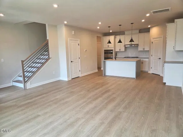 a large kitchen with stainless steel appliances kitchen island a large counter top and a stove top oven