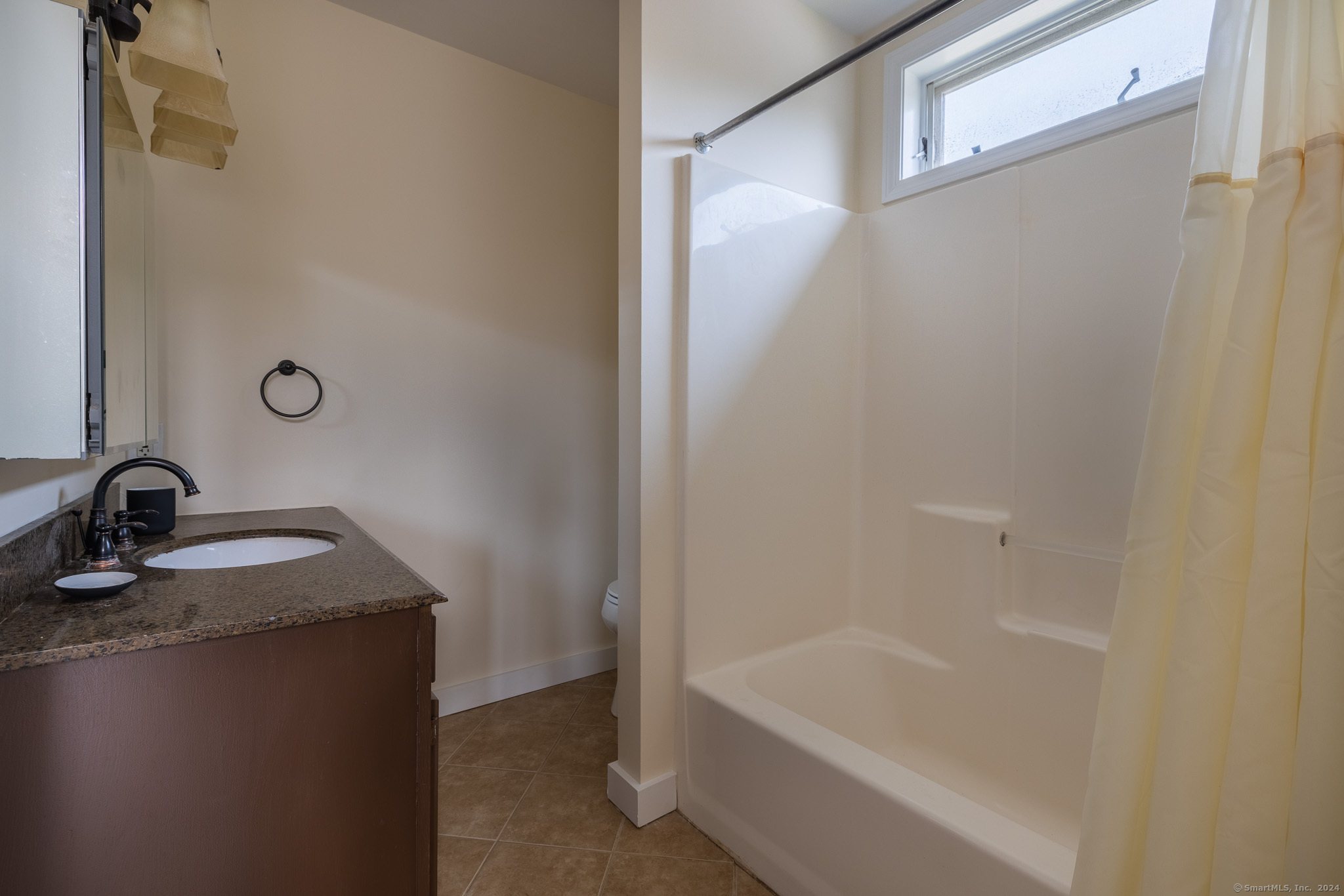 916 Reef Road Fairfield, CT 06824 - Photo 11 of 16 a bathroom with a granite countertop sink and a bathtub