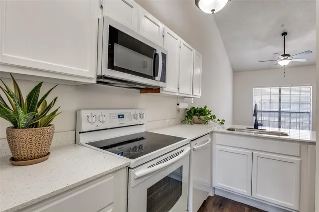 a kitchen with a sink a microwave and cabinets