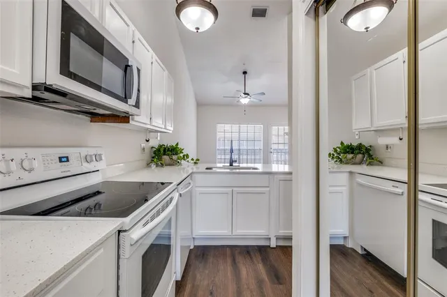a kitchen with stainless steel appliances granite countertop a sink a stove and cabinets