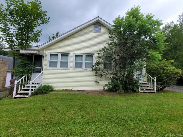 a view of a house with backyard and a tree