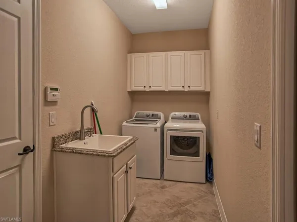 a utility room with sink dryer and washer