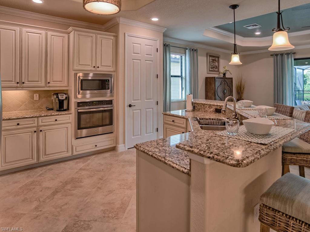 2850 Aviamar Circle Naples, FL 34114 - Photo 9 of 26 a kitchen with stainless steel appliances granite countertop a sink stove and refrigerator