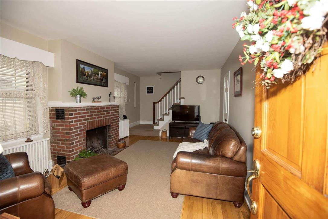 706 Stones Crossing Road Easton, PA 18045 - Photo 5 of 40 Enter into a inviting living area featuring a classic brick fireplace and rich hardwood flooring.