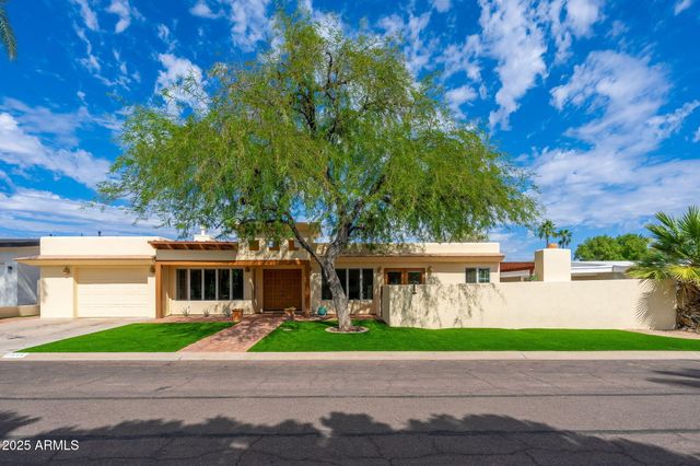 a view of a brick house with a yard next to a road