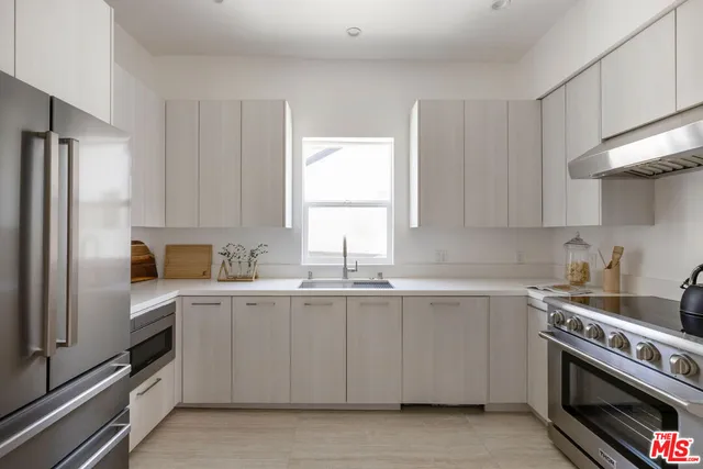 a kitchen with white cabinets and appliances