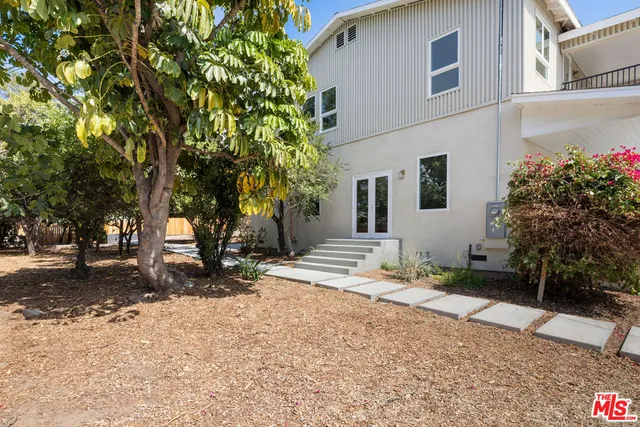 a living room with patio furniture and a large tree