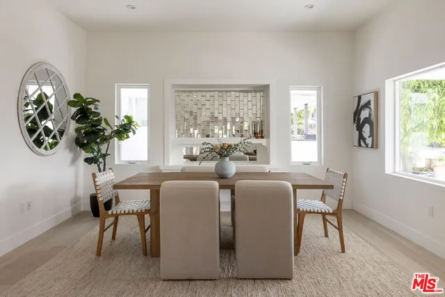a dining room with wooden floor a chandelier a wooden table and chairs