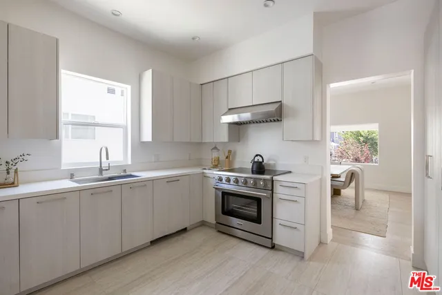 a kitchen with stainless steel appliances a sink cabinets and a window