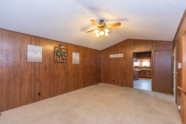 a view of a livingroom with a chandelier fan and a kitchen