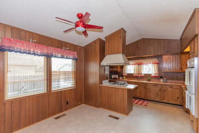 a kitchen with stainless steel appliances granite countertop a stove a sink dishwasher and a refrigerator