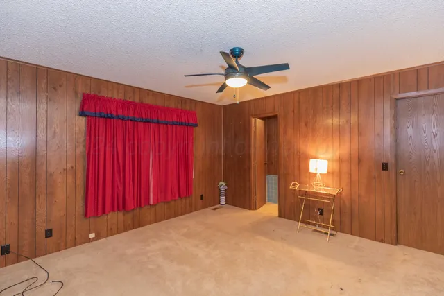 a view of a room with a window and a ceiling fan