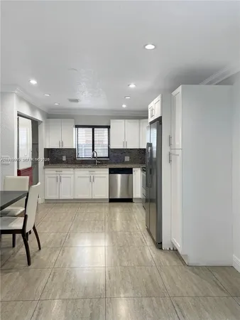 a kitchen with stainless steel appliances granite countertop a refrigerator and a stove top oven