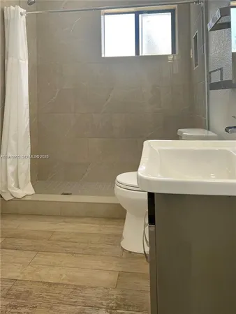 a bathroom with a sink a toilet and shower