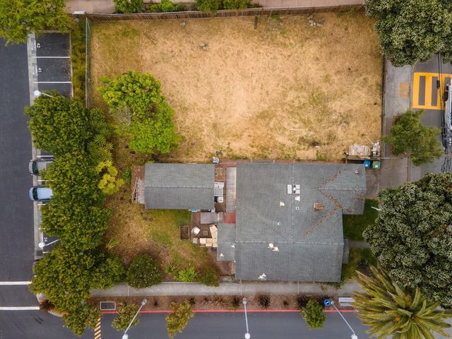 an aerial view of residential houses with outdoor space and trees