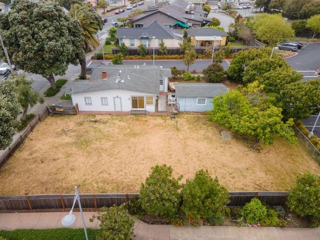 a aerial view of a house with swimming pool and large trees