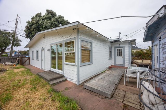 a view of a house with backyard and sitting area