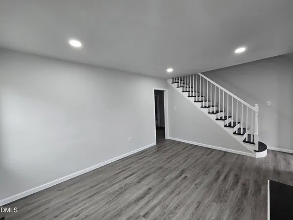 a view of an empty room with wooden floor