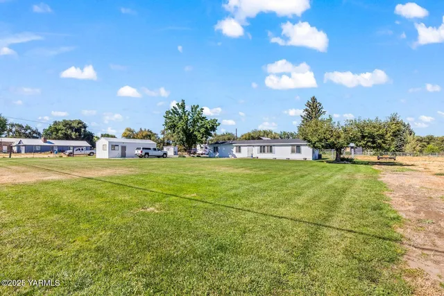 a view of yard with swimming pool and green space