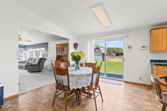 a dining room with furniture and a floor to ceiling window