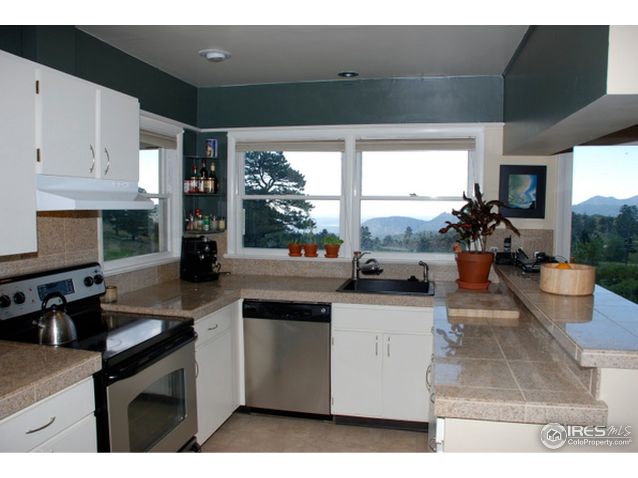 58 Old Post Office Road Boulder, CO 80302 - Photo 5 of 16 a kitchen with stainless steel appliances kitchen island granite countertop a sink and white cabinets