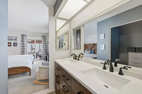 a en suite bathroom with a double vanity sink and a mirror