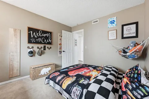 a bedroom with a bed and a painting on the wall