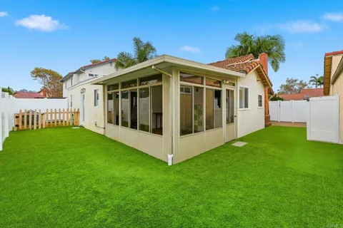 a view of a white house with a big yard and large trees