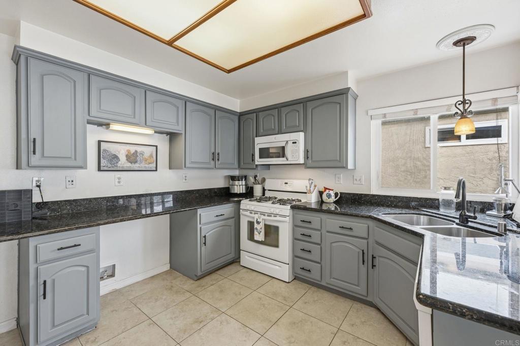 270 Chestnut Way Oceanside, CA 92057 - Photo 3 of 43 a kitchen with granite countertop white cabinets and white appliances