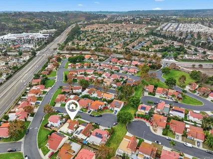 an aerial view of residential houses with outdoor space and parking