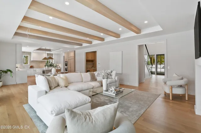 a kitchen with kitchen island granite countertop a stove a sink a dining table and chairs with wooden floor