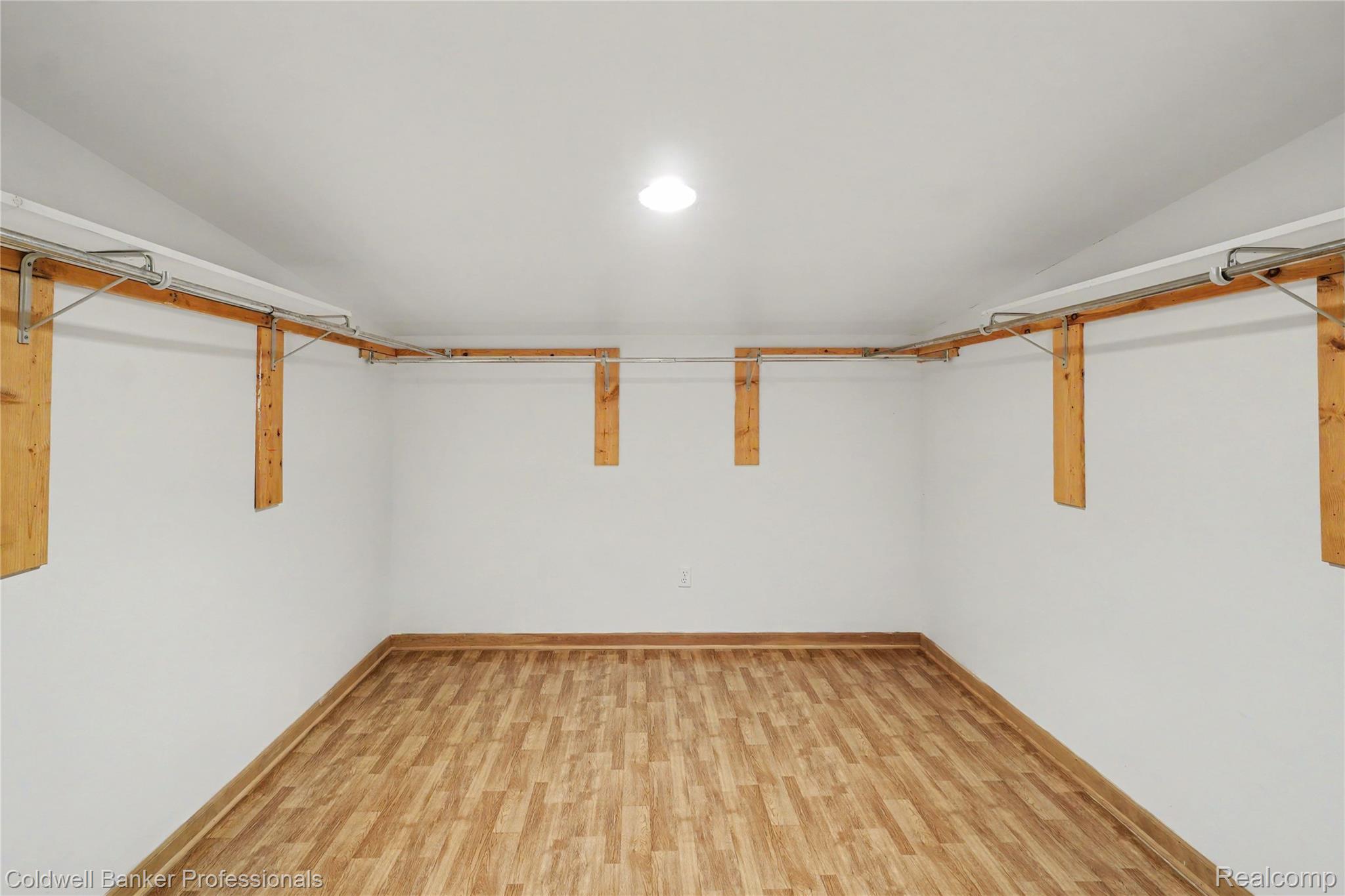 3583 Mitchell Road Metamora, MI 48455 - Photo 46 of 58 Interior room featuring wood-finish flooring, white walls, and a built-in hanging rod system