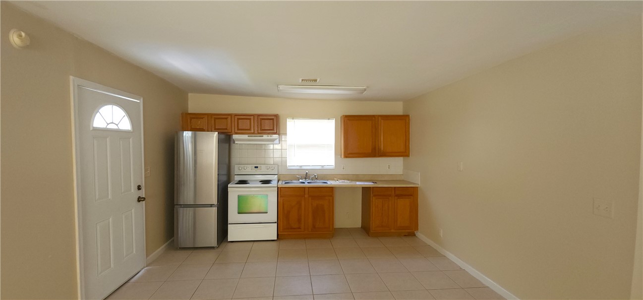 1860 38th Street Vero Beach, FL 32960 - Photo 6 of 8 a view of a kitchen with a sink a refrigerator and window