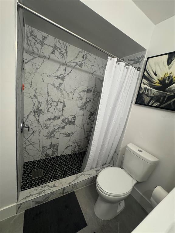 1935 South Conway Road, Unit T6 Orlando, FL 32812 - Photo 19 of 33 a white toilet sitting next to a shower curtain