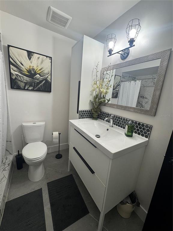 1935 South Conway Road, Unit T6 Orlando, FL 32812 - Photo 20 of 33 a bathroom with a sink mirror vanity and toilet