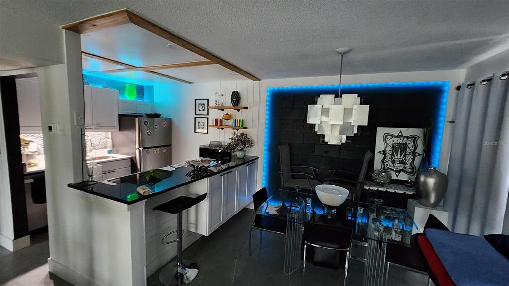 1935 South Conway Road, Unit T6 Orlando, FL 32812 - Photo 2 of 33 a kitchen with stainless steel appliances granite countertop a refrigerator a stove and a dining table with wooden floor