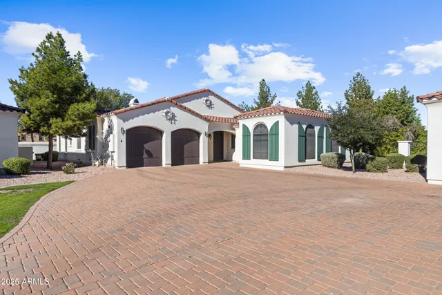 a view of a white house with a yard and potted plants