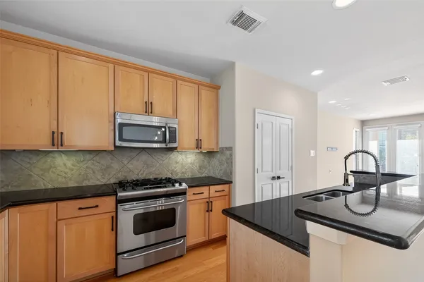 a kitchen with granite countertop a sink and white cabinets