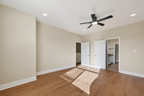 a view of a room with wooden floor and ceiling fan