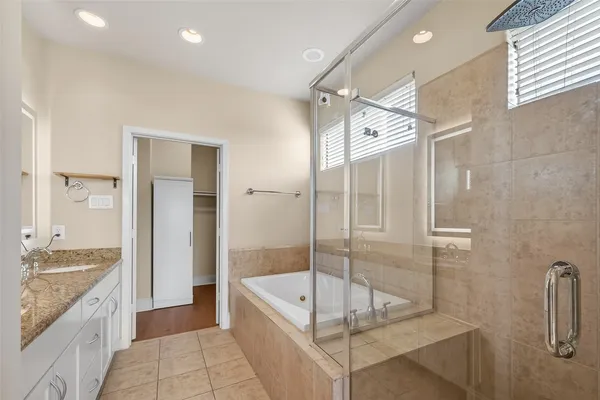a bathroom with a granite countertop sink mirror bathtub and shower