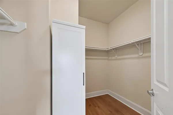 a view of an empty walk in closet with wooden floor