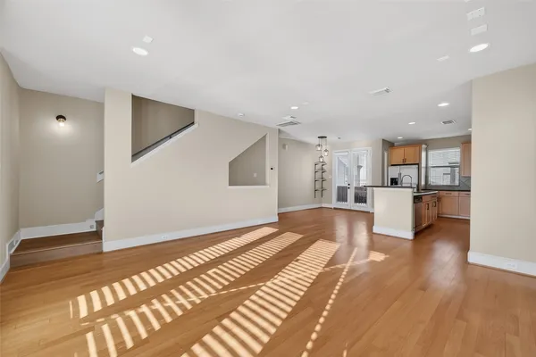 a view of a big room with wooden floor and a kitchen