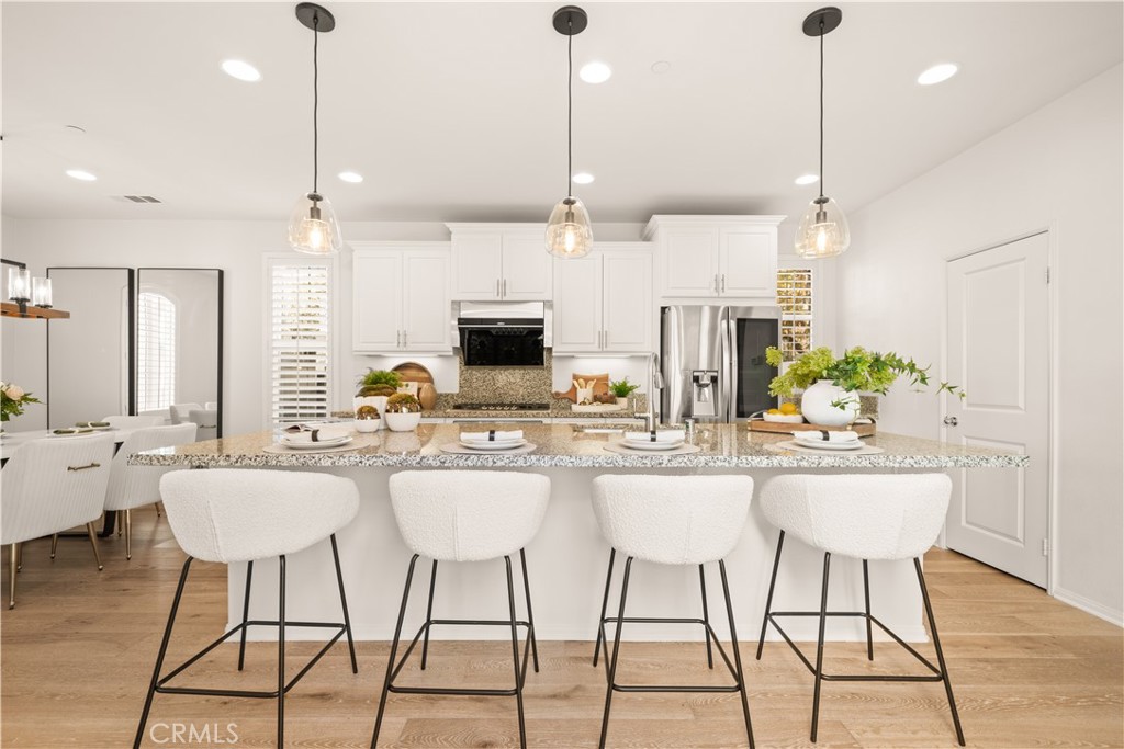 161 Fixie Irvine, CA 92618 - Photo 11 of 47 a kitchen with stainless steel appliances kitchen island granite countertop a table chairs and a white cabinets