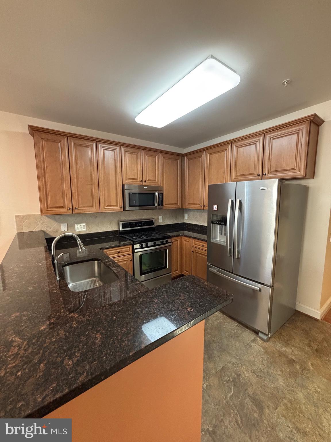 7300 Travertine Drive, Unit 302 Baltimore, MD 21209 - Photo 13 of 30 a kitchen with granite countertop a refrigerator and a sink