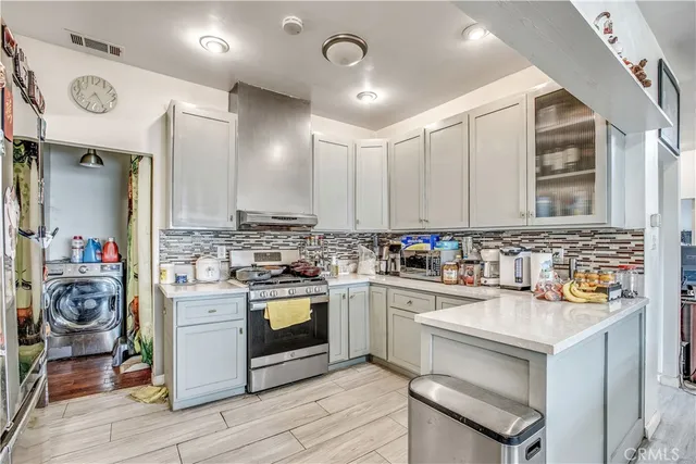 a kitchen with stainless steel appliances granite countertop a sink a stove and cabinets