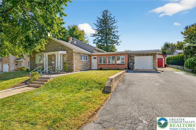 a view of a house with a yard and potted plants