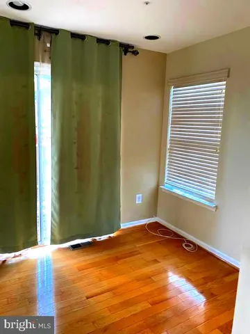 a view of empty room with window and wooden floor