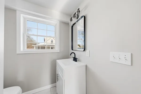 a bathroom with a sink mirror and toilet