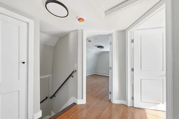 a view of a hallway with wooden floor and staircase